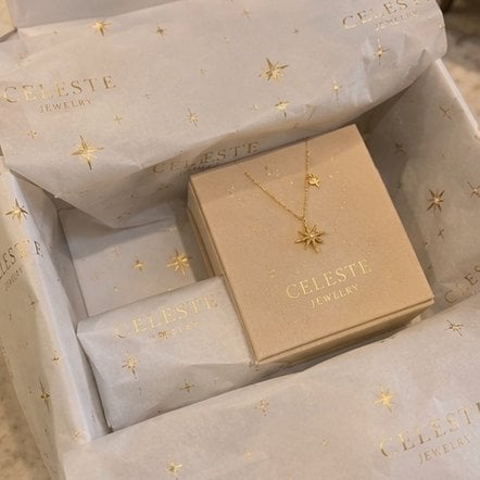Metallic foil printed custom tissue paper catching the light in an opened gift box